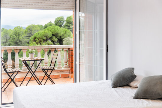 Scenic bedroom with open balcony and green landscape view