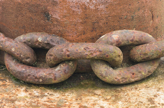 Close-up of Rusty Chain Links in a Junkyard Setting