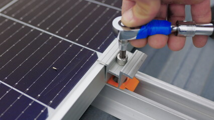 Close up of worker installing and working on maintenance of photovoltaic panel system installed. Mounting solar panel, installing solar panels on the roof of the house. Connection of solar panels