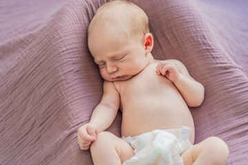 The baby is sleeping peacefully in his cozy nest. Newborn photo session captures the serene innocence and warmth of early moments