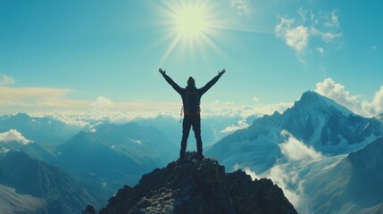 A person standing at a mountain peak, arms raised in triumph, symbolizing achievement and reaching a significant goal.