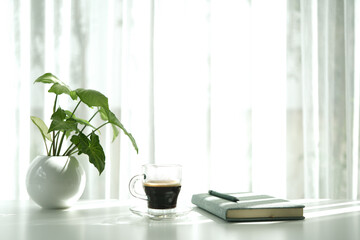 coffee cup and pothos plant pot on white table minimal interior