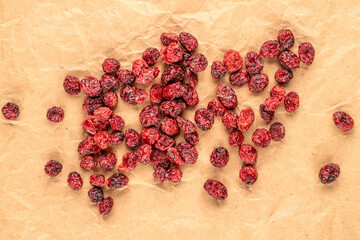 Dried cranberries on kraft paper and top view, macro.