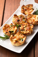 Deliziosi fagottini di pasta sfoglia cotti al forno e ripieni di uova, zucchine e mozzarella, antipasti italiani 
