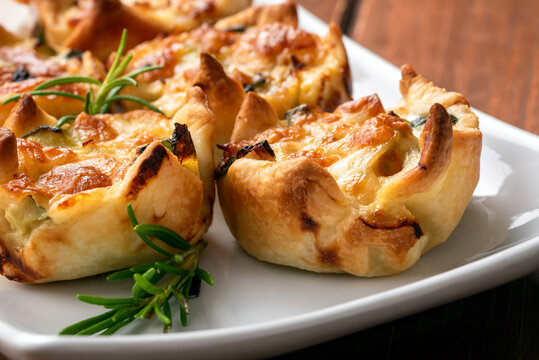 Deliziosi fagottini di pasta sfoglia cotti al forno e ripieni di uova, zucchine e mozzarella, antipasti italiani 