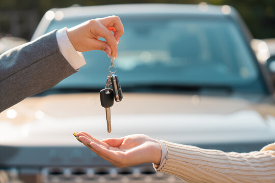 Car sale, Woman hands car keys to girl