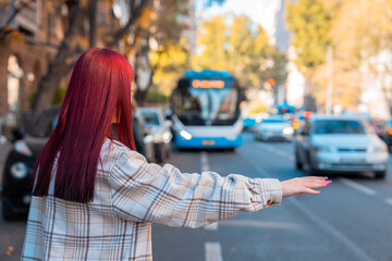 At the city bus stop, the girl tries to stop the bus and the car with her hand