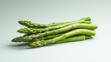 A vibrant image featuring a fresh bunch of asparagus stalks neatly arranged on a pale background, emphasizing their vivid green color and crisp texture.