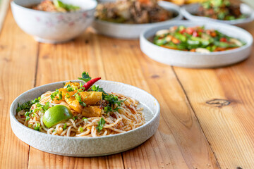 The Khao Soi Yuan Naan that is served on the plate is Khao Soi noodles mixed with minced pork spring onion coriander and chili lime and sesame spicy and sour. noodles chinese food tai yai food