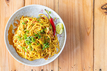 The Khao Soi Yuan Naan that is served on the plate is Khao Soi noodles mixed with minced pork spring onion coriander and chili lime and sesame spicy and sour. noodles chinese food tai yai food
