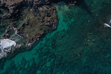 Maui lava rocks and the shallow blue reef on a clear day