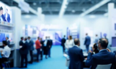 Blurry conference hall with people in business attire. Suitable for presentations, business websites, corporate events, and promotional materials.