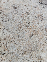 Close-up of natural stone texture with different shades of grey, brown and white. Natural cracks and patterns create a striking and unique texture.