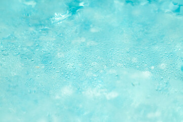 A close-up view of a clear, turquoise pool with ripples on the surface