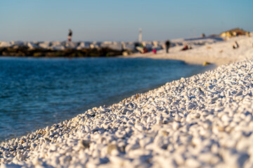 Marina di Pisa, Italy - November 4, 2024: View of the beach with snow-white stones. White stone pebbles.
