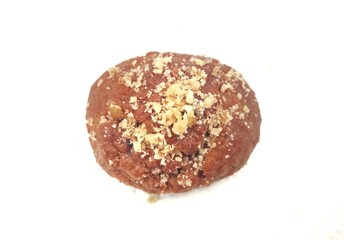 Top view of a Greek melomakarono, a traditional honey-soaked Christmas dessert, topped with crushed walnuts, isolated on a white background. 