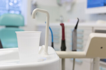 Close-up of disposable white plastic mouth rinse cups, aspirators probes and air blower attachments...