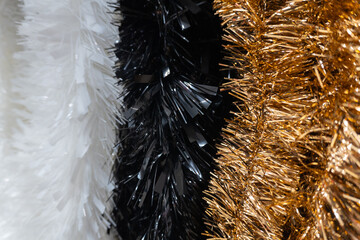 Combination of black, gold, and white tinsel in a unique mix that adds mystery and elegance to the texture. Metallic strands in contrasting colors create an aura of luxury and holiday magic.