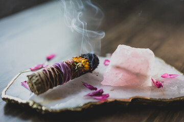 burning sage stick on crystal tray on wood table
