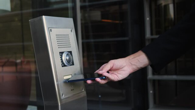 Businessman man using an access nfc phone to enter an elegant modern office. Coworking business office safety, professional environments and advanced technology in the workplace.