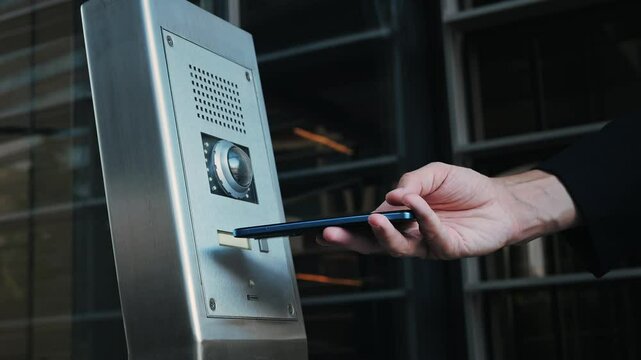 Businessman man using an access nfc phone to enter an elegant modern office. Coworking business office safety, professional environments and advanced technology in the workplace.