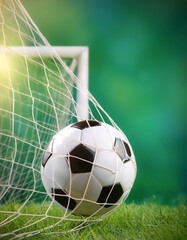 soccer ball in goal with green backgroung