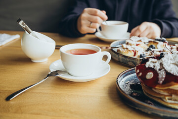 A man drinks tea in a cafe during breakfast, the concept of a sweet breakfast.