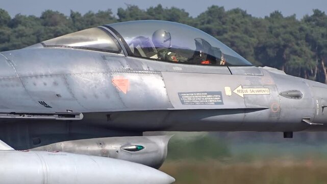 military fighter jet cockpit reveals pilot full gear ready for action engines roaring airbase buzzing preparation combat operations close up view air force exterior jetsuit 