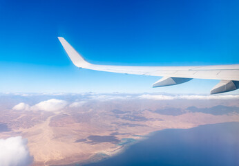 Fototapeta premium View from the airplane window of the mountains and sea resort with corals in Egypt, Sharm El Sheikh.Flight