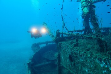 Rusty wreck and scuba diver videographer. Scuba diving, wreck exploration. Travel photo, shipwreck...