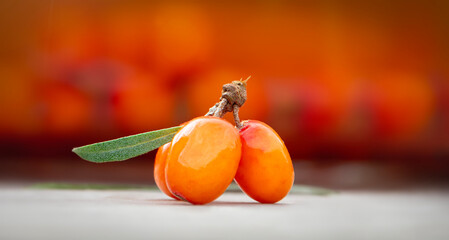 Close-up of sea buckthorn berries against the background of sea buckthorn tea. Macro photography of sea buckthorn berry.