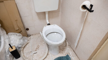 A neglected, unsanitary bathroom with a dirty toilet and scattered debris emphasizing hygiene...