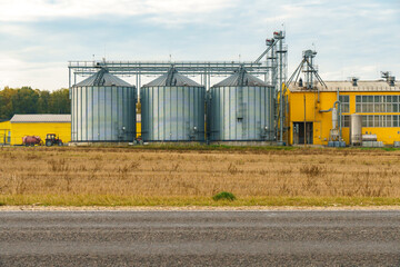 silver silos on agro manufacturing plant for processing drying cleaning and storage of agricultural...