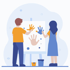 A boy and a girl are painting hands on a white canvas. The boy is wearing an orange shirt and the girl is wearing a blue dress. The painting is a collaborative effort between the two