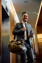 Happy businessman carrying sports bag while going on sports training at  gym.