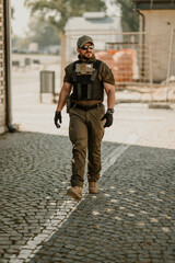 Soldier walking on cobblestone street wearing tactical gear