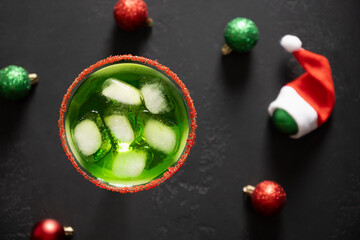 Xmas Green Punch in glass decorated sugar rim on black table make of cool lime sherbet. Tasty drink for Christmas holiday. Rim your festive beverages in red sugar. Close up.