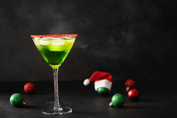 Xmas Green Punch in glass decorated sugar rim on black table make of cool lime sherbet. Tasty drink for Christmas holiday. Rim your festive beverages in red sugar. Close up. Copy space