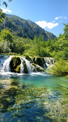 Obraz premium Beautiful Waterfall Cascading in a Lush Mountainous Landscape on a Sunny Day. Concept of Natural Beauty, Scenic Outdoors, Tranquility, and Refreshing Environments. Vertical