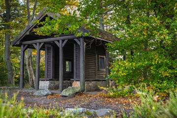 Karkonosze Mountains, Western Sudetes, public tourist shelter on the top of Sepia Gora mountain. Wooden shelter between trees on a mountain hiking trail.