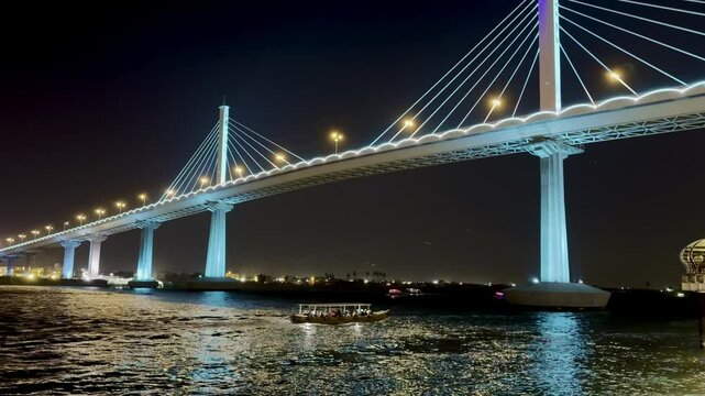 Basra, Iraq - November 13, 2024: Night view of illuminated bridges over reflective water