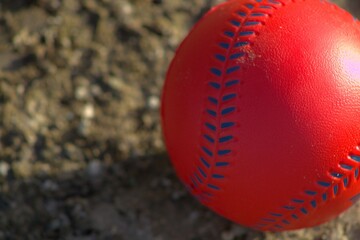 red plastic baseball toy with blue stitches 