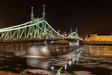 Obraz premium Liberty Bridge at night during winter above the icy Danube with long exposure in Budapest Szabadság híd 