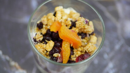 Yogurt with granola, forest fruits and dried apricots