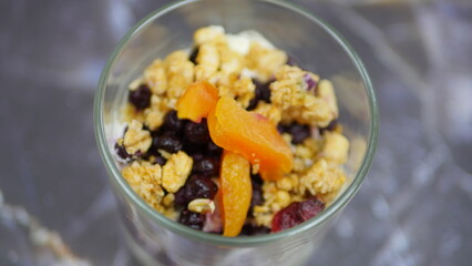 Yogurt with granola, forest fruits and dried apricots