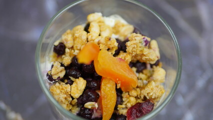 Yogurt with granola, forest fruits and dried apricots