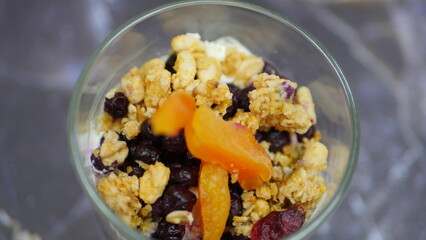 Yogurt with granola, forest fruits and dried apricots