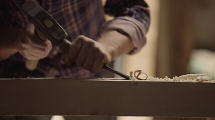 Extreme close-up view of a master carpenter makes basting on the wooden board, craftsman work tool in the workshop