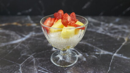 Dessert of tapioca balls with pineapple and mango in an ice cream cup