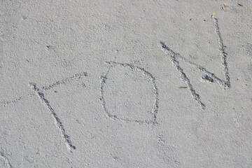 TON carved into pavement sidewalk